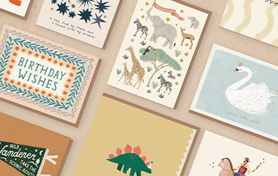 an image showing several of our greeting cards laid out on a pink background