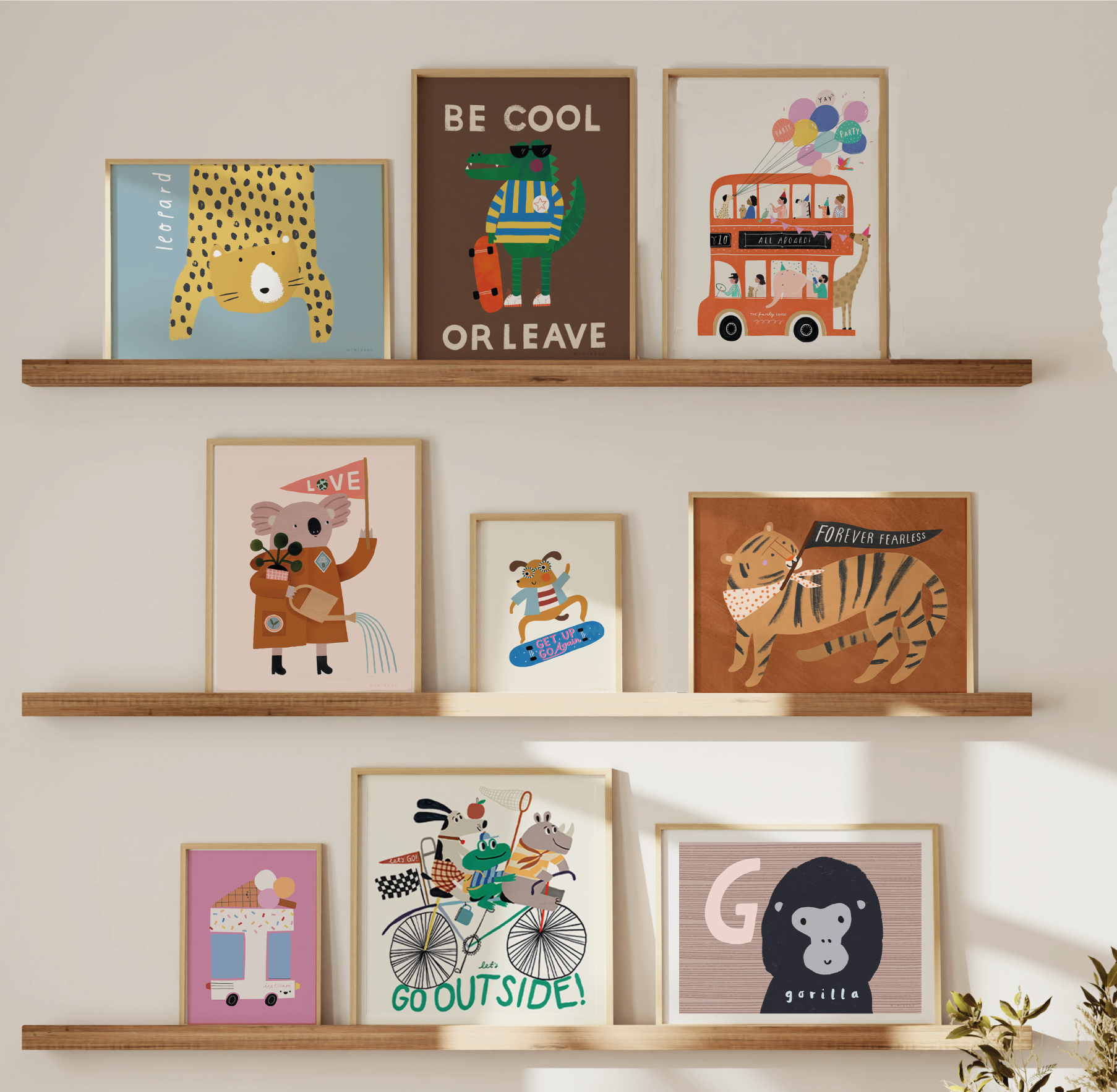 A gallery wall made up of 9 a colourful life art prints on oak picture shelves
