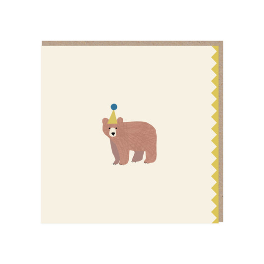 Square greetings card. Off white background with a brown bear standing on all fours wearing a yellow/gold party hat with a blue pom pom. a zigzag edge in the same yellow/gold colour is on the right/open side. Comes with a brown kraft envelope